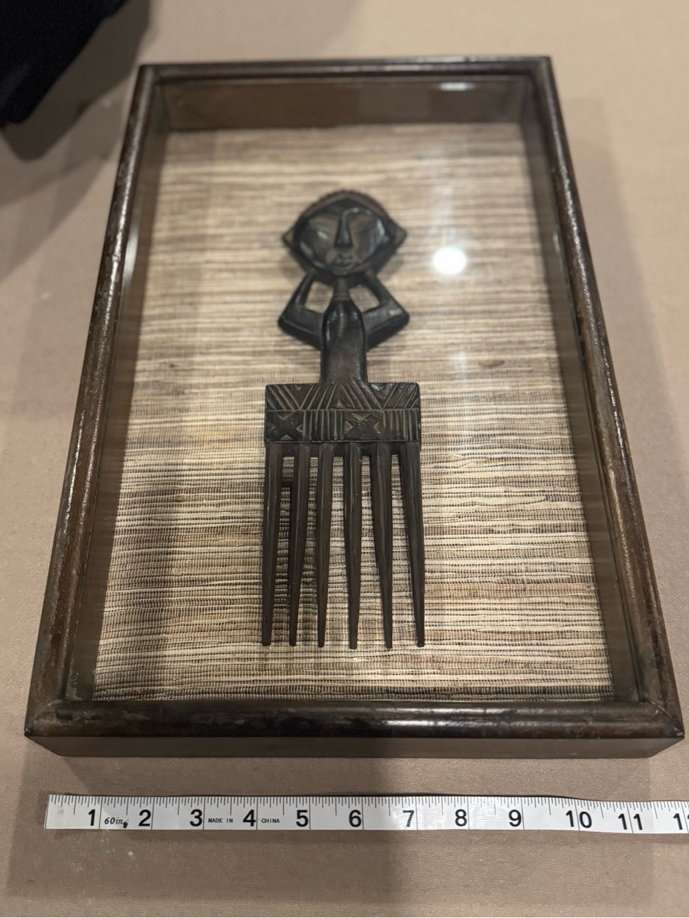 Decorative African carved comb/hair ornament, mounted in a shadow-box frame